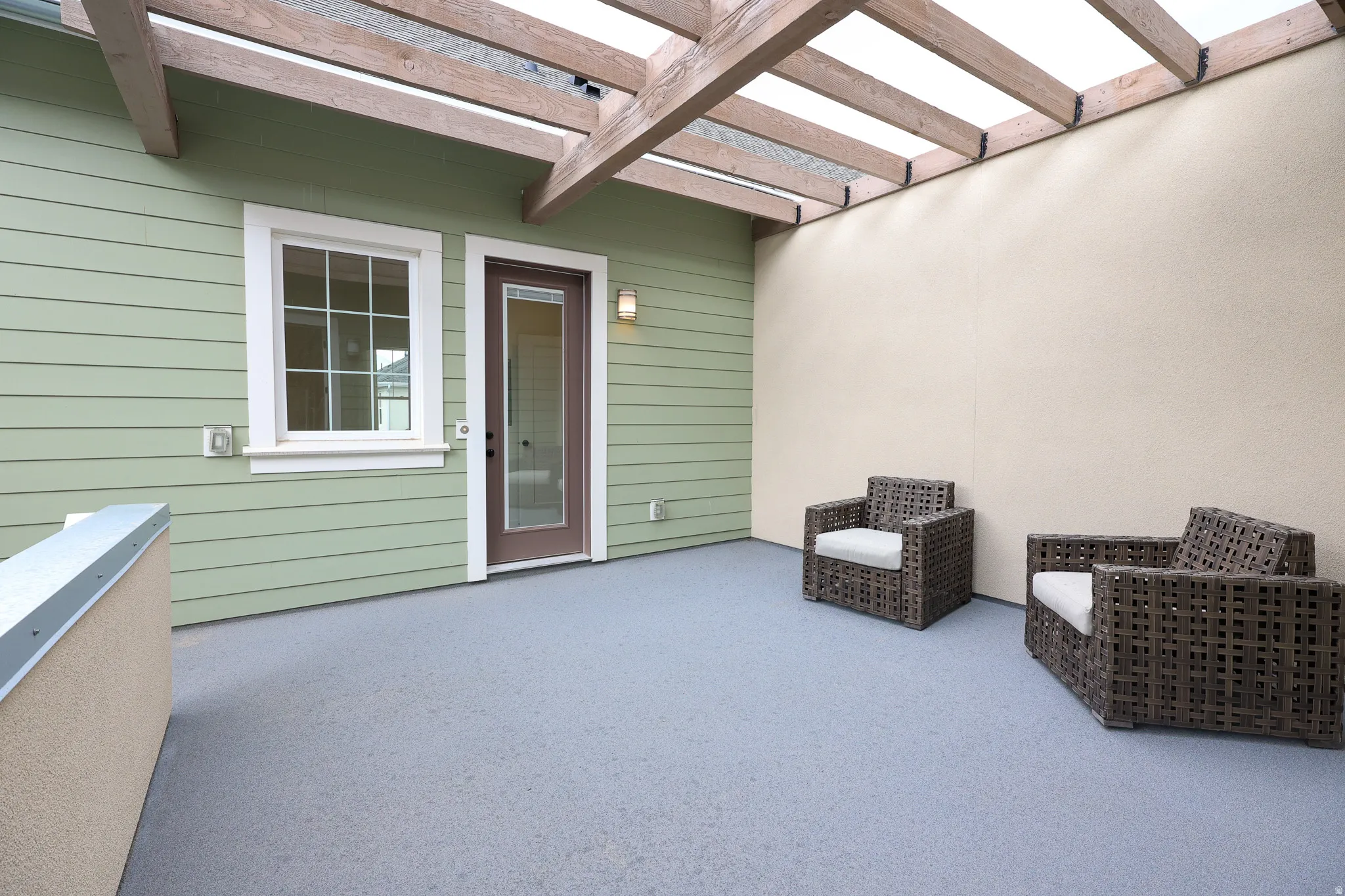 Private patio with a durable floor finish, overhead pergola, and direct access