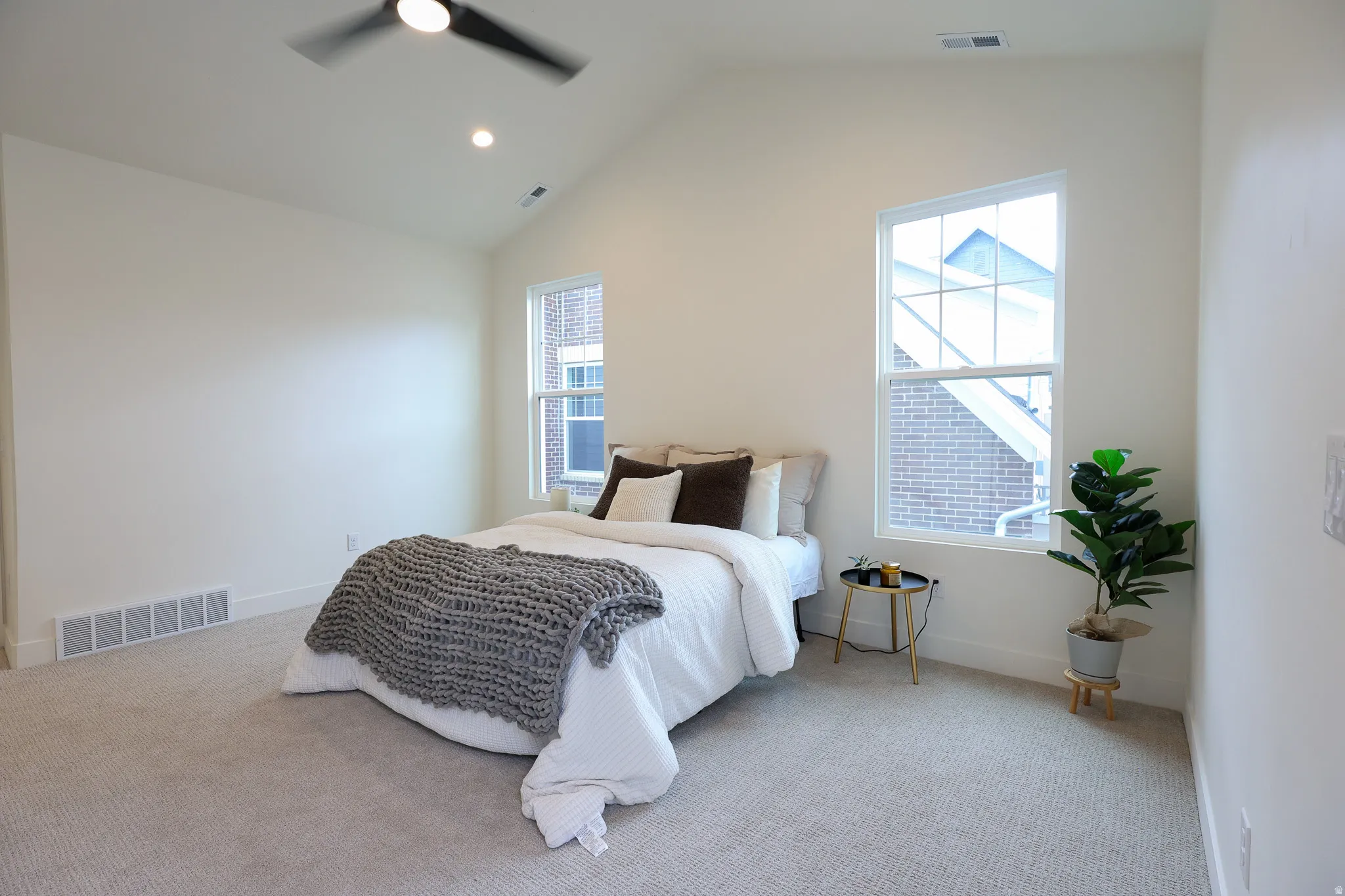 Primary bedroom with Vaulted ceiling with recessed lighting and a ceiling fan
