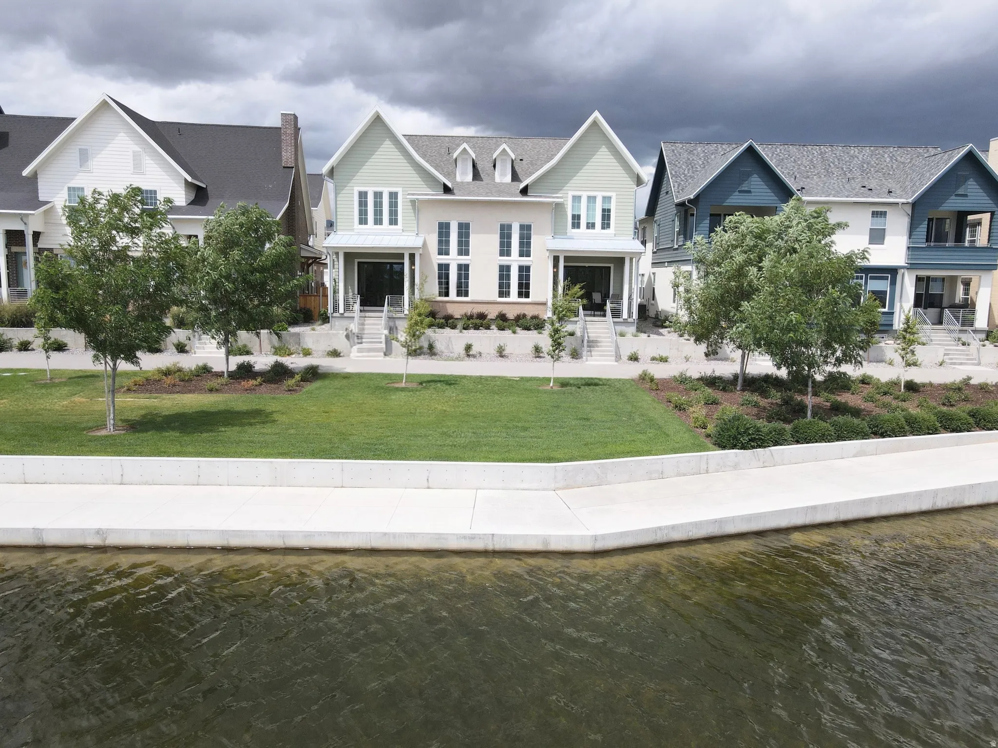 Waterfront property featuring a contemporary architectural style and a manicured lawn