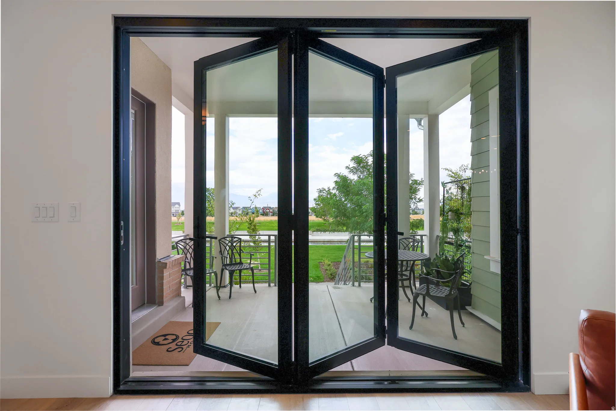 Bi-fold glass doors opening to a covered patio with a concrete floor