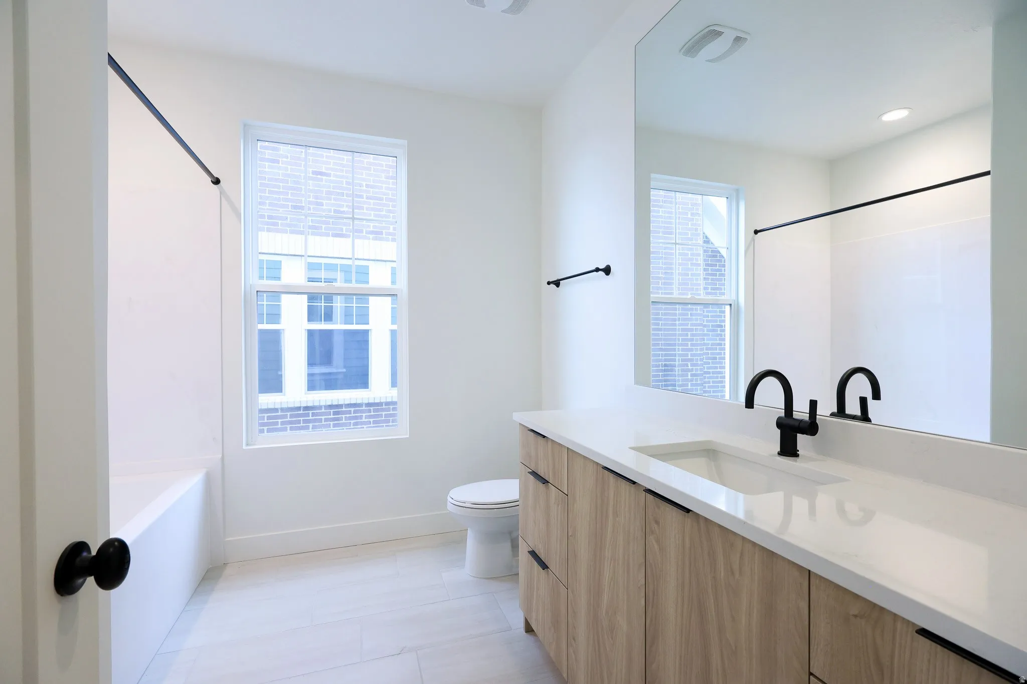 Upper full bathroom Vanity with wood-finish cabinetry, integrated sink, and white countertop