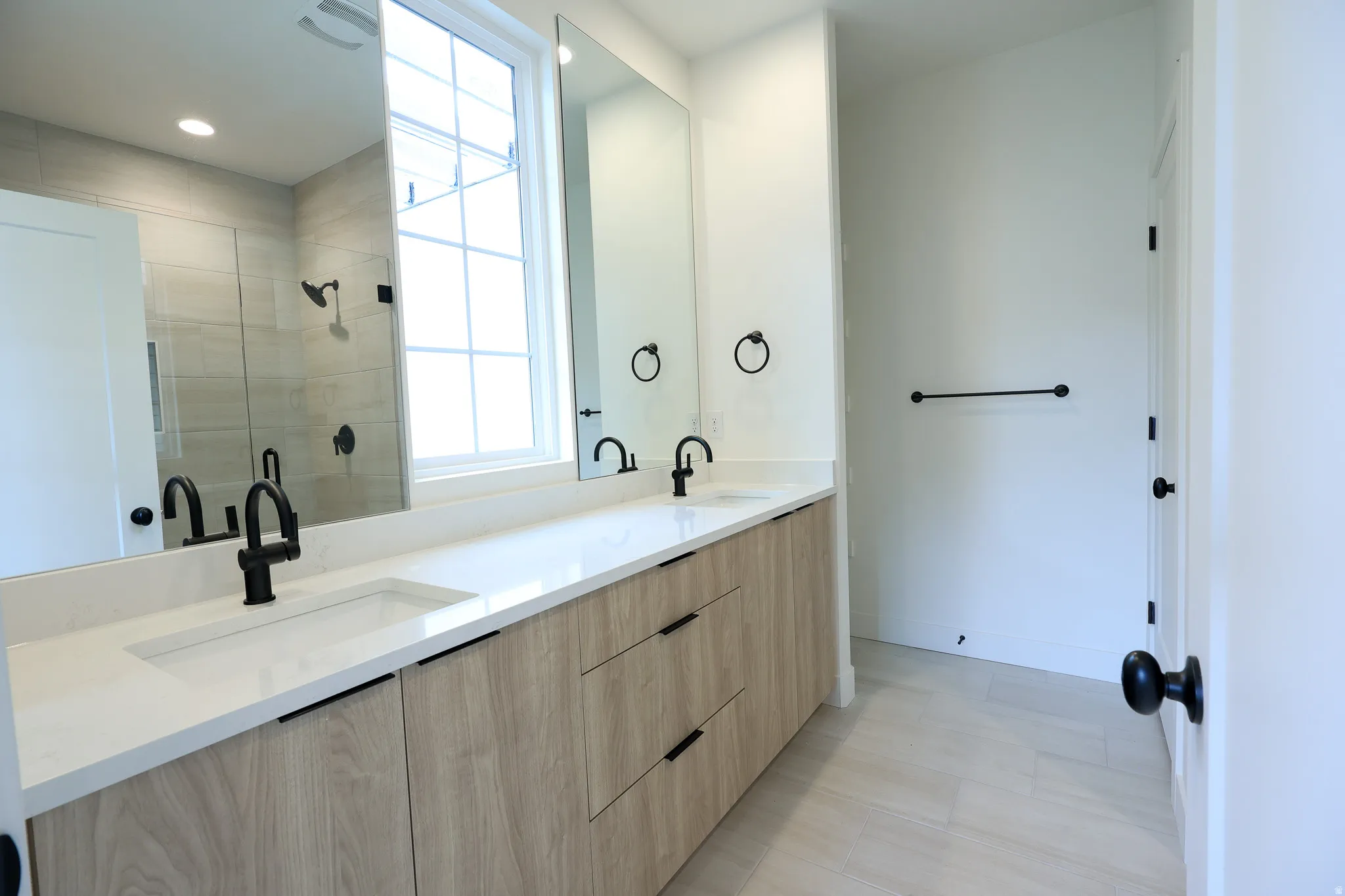 Primary bathroom -Dual vanity with wood-finish cabinetry and integrated sinks