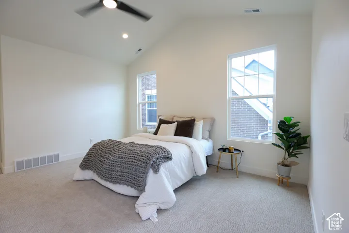 Primary bedroom with Vaulted ceiling with recessed lighting and a ceiling fan