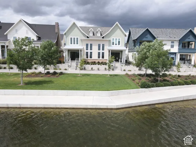 Waterfront property featuring a contemporary architectural style and a manicured lawn