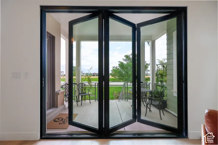 Bi-fold glass doors opening to a covered patio with a concrete floor