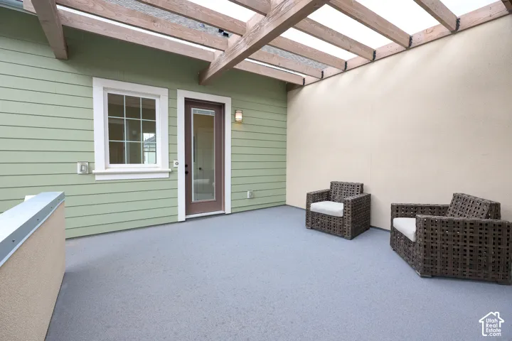 Private patio with a durable floor finish, overhead pergola, and direct access