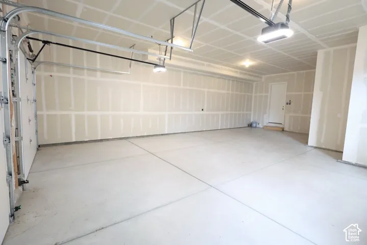 Concrete flooring, built-in overhead lighting, and an overhead garage door mechanism