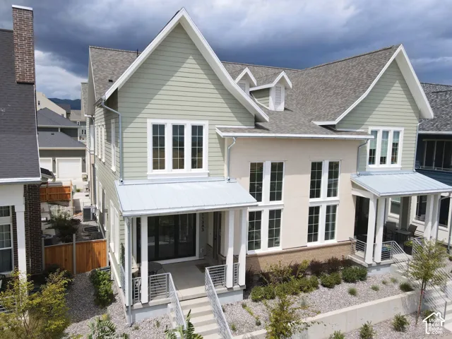 Modern farmhouse design featuring a crisp white exterior with horizontal siding, steeply pitched gable rooflines, and multiple dormer windows