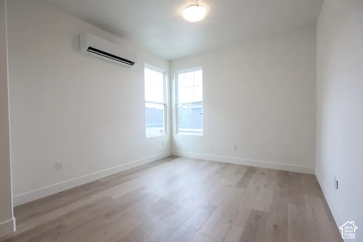 ADU-Light wood-finish flooring, white walls, and a flush mount ceiling light
