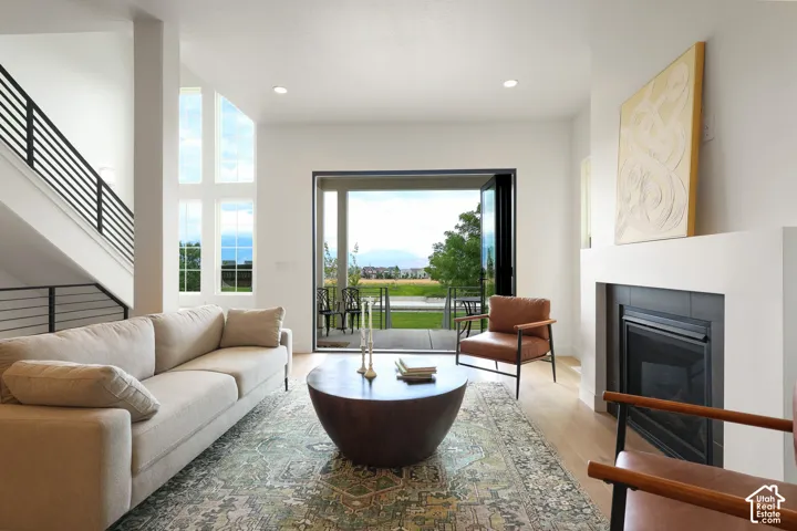 Spacious living area featuring a modern fireplace, light wood-finish flooring, and a multi-pane window configuration
