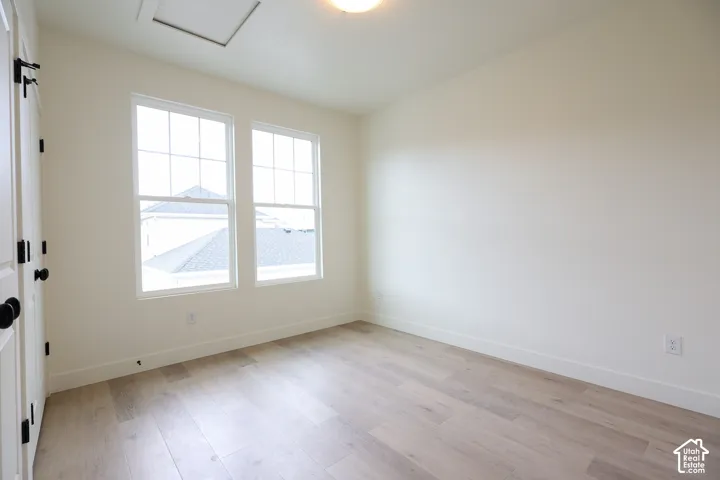 ADU-Light wood-finish flooring, two large windows with grid patterns, and an overhead lighting fixture