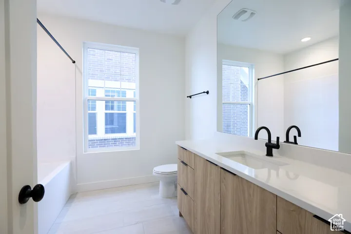 Upper full bathroom Vanity with wood-finish cabinetry, integrated sink, and white countertop