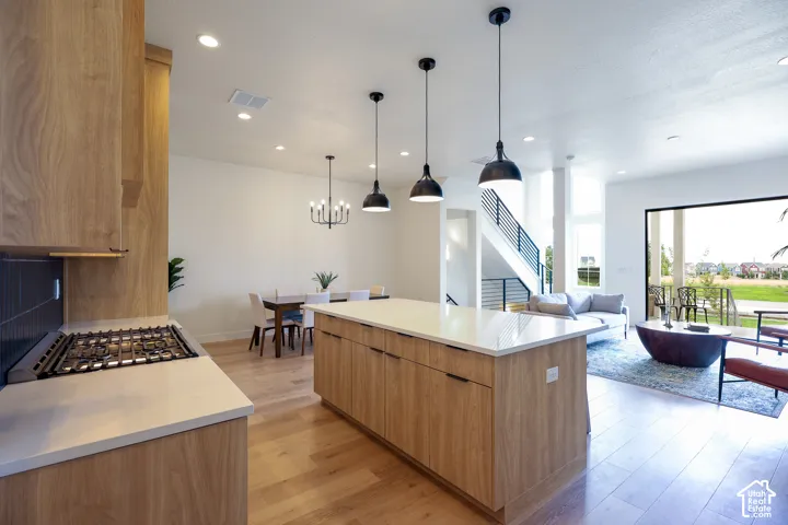 Open-concept layout featuring wood-finish flooring and recessed lighting