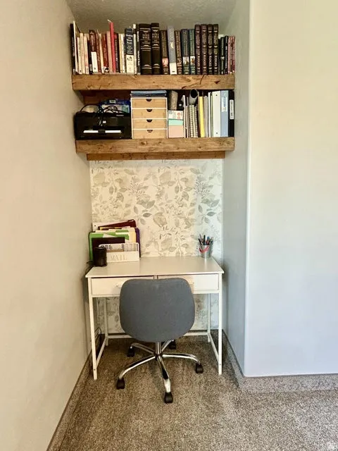 Built-in wood-finish shelving with a patterned accent wall