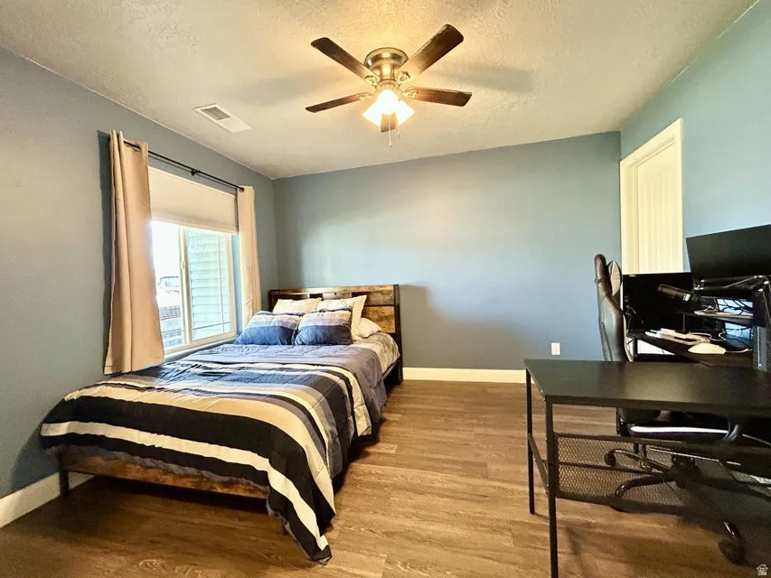 Wood-finish flooring throughout, complemented by a ceiling fan with integrated lighting