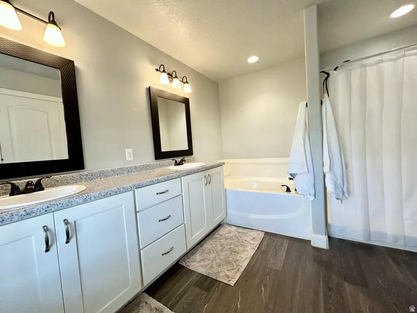 Dual vanity with white cabinetry, speckled countertops, and undermount sinks