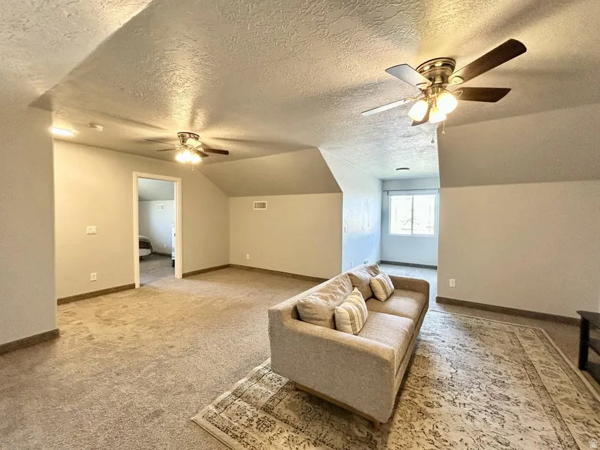 Carpeted flooring, vaulted ceiling, recessed lighting, and dual ceiling fans