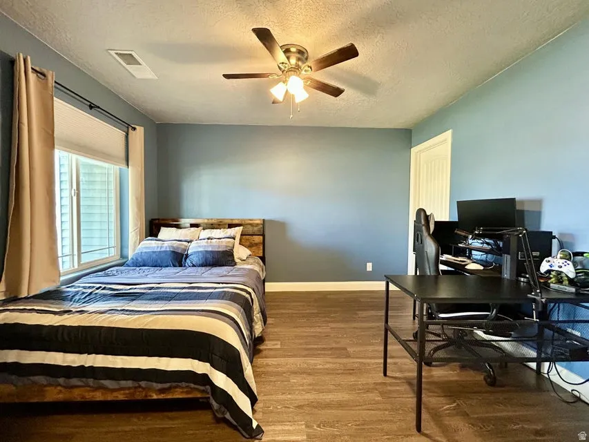 Recessed window with blinds, wood-finish flooring, ceiling fan, and painted walls