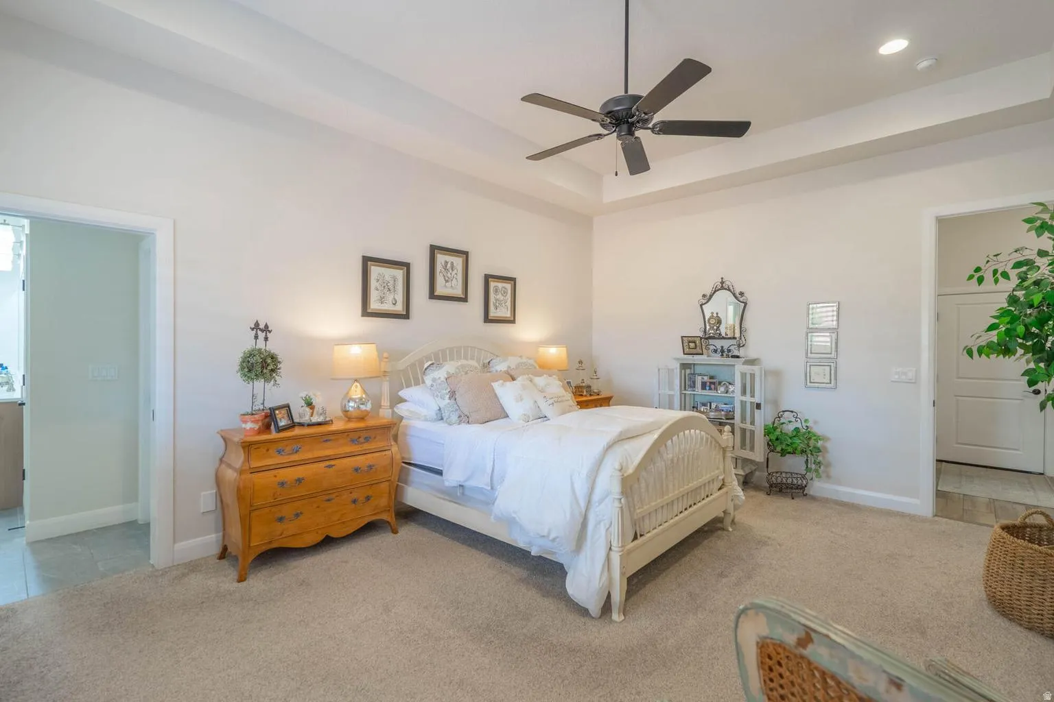 Tray ceiling with recessed lighting, ceiling fan, and carpeted flooring