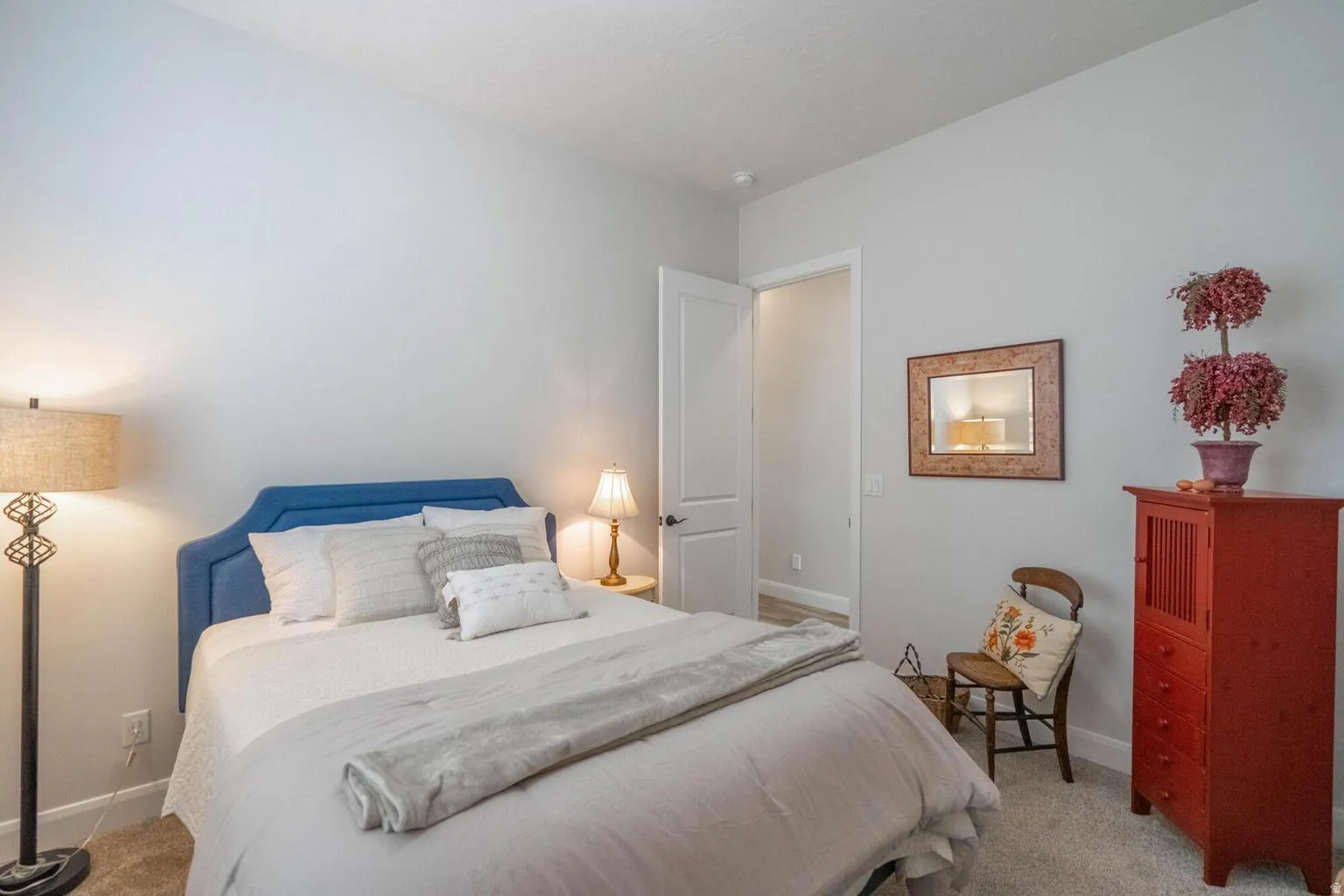 Plush carpeting, light gray wall color, white trim, and a white interior door with a dark handle