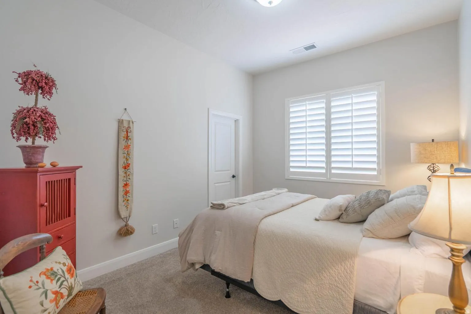 Carpeted flooring, vaulted ceiling, white interior door, plantation shutters