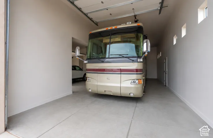 Spacious garage with high ceilings, multiple transom windows, and a dedicated entry door
