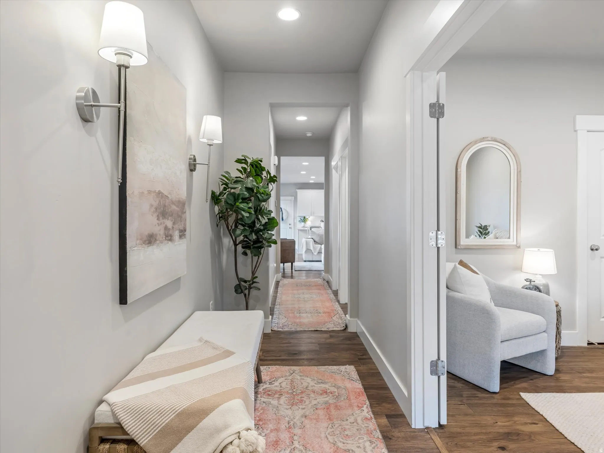 Hallway with wood-finish flooring, recessed lighting, and wall sconces