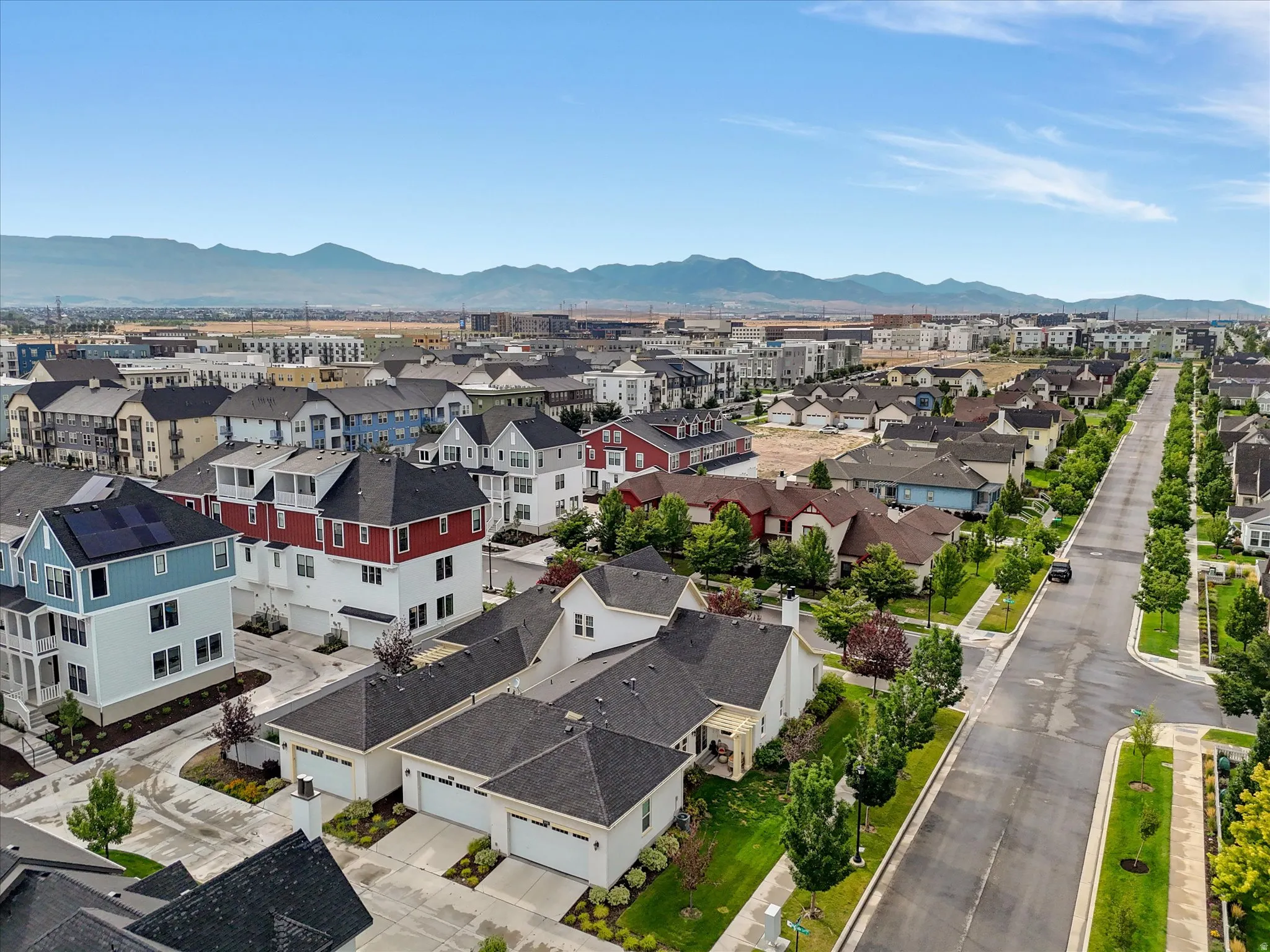 Residential neighborhood with established streets, mature trees, and mountain scenery