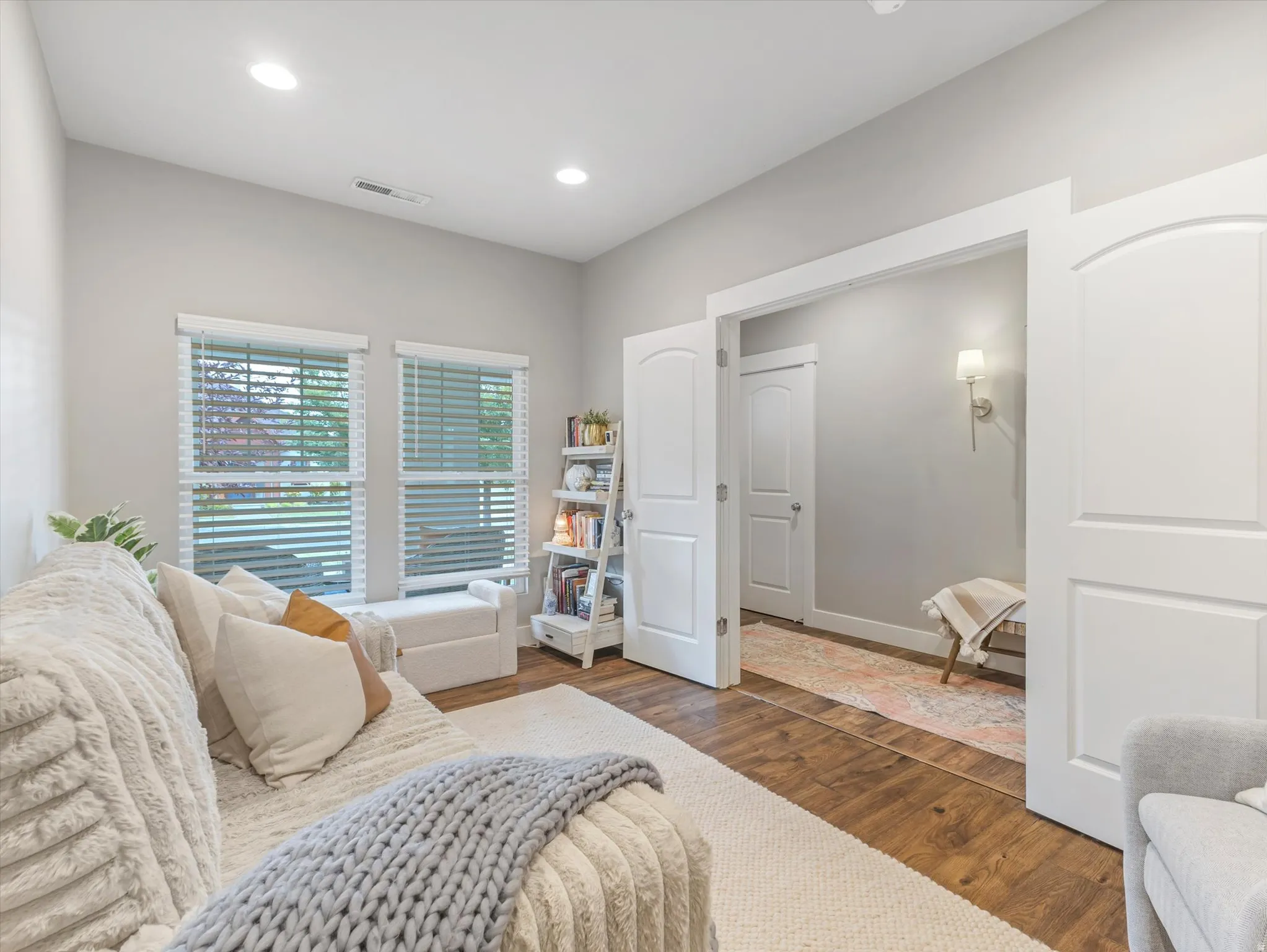 Recessed lighting, two windows with blinds, wood-finish flooring, and white interior doors