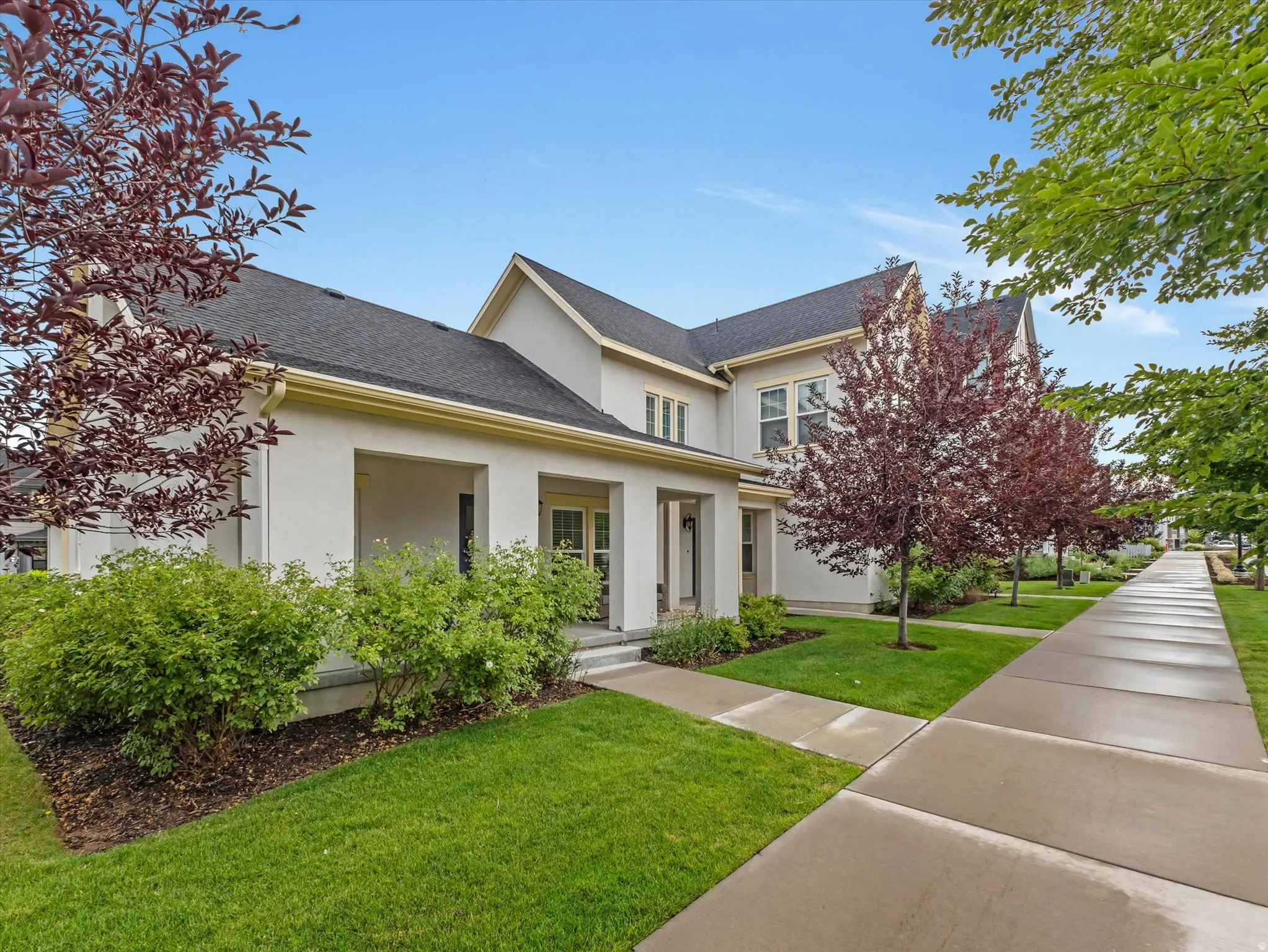 Contemporary stucco exterior with a dark shingle roof