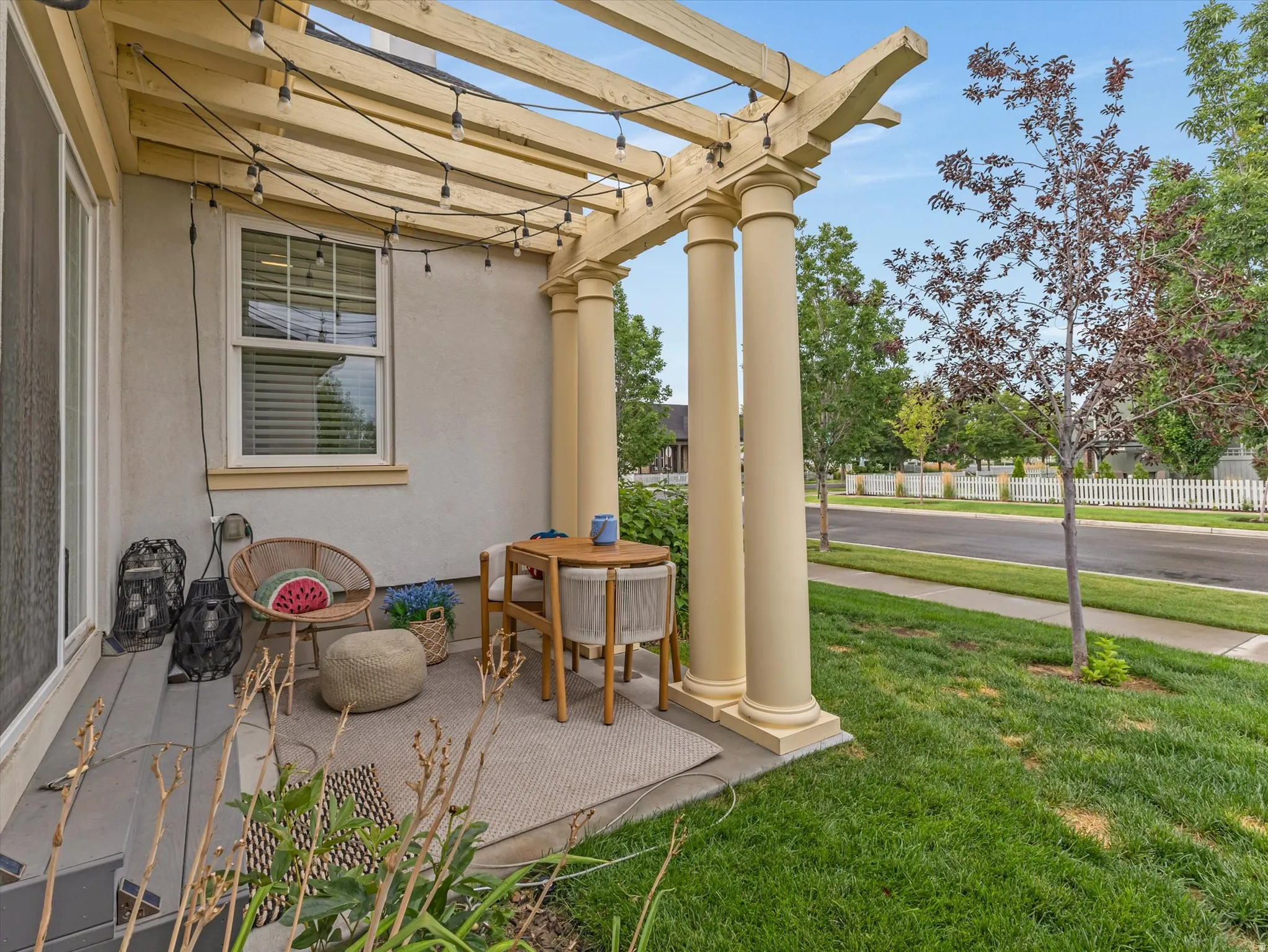 Covered patio featuring a wood pergola and classic columns