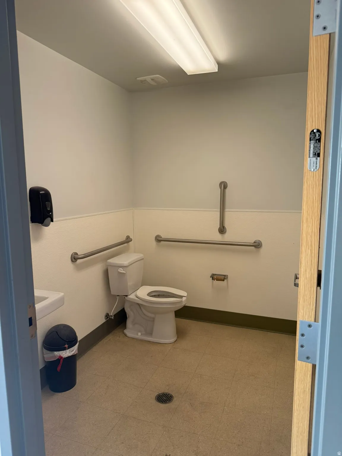 White tile flooring, white walls, and a white toilet