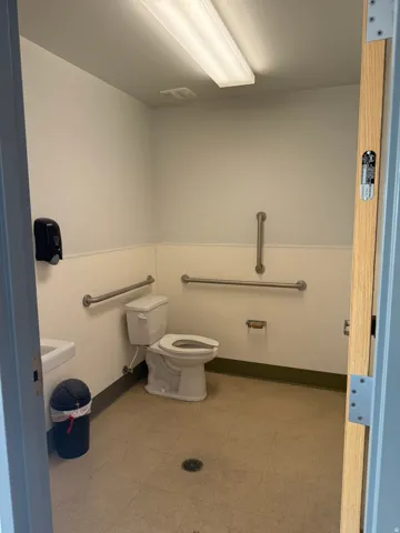 White tile flooring, white walls, and a white toilet