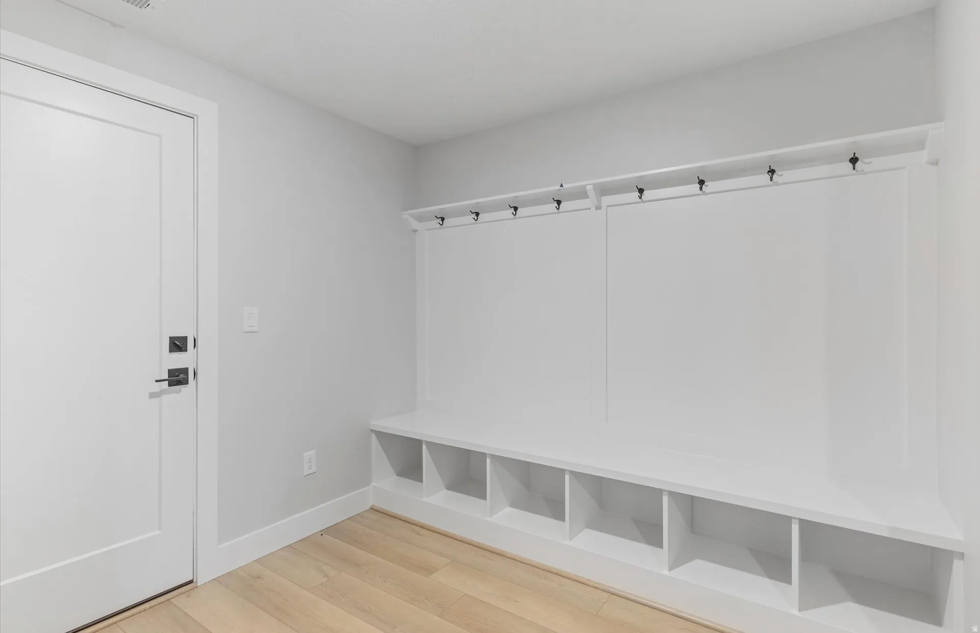 Built-in storage bench with individual cubbies and wall-mounted hooks
