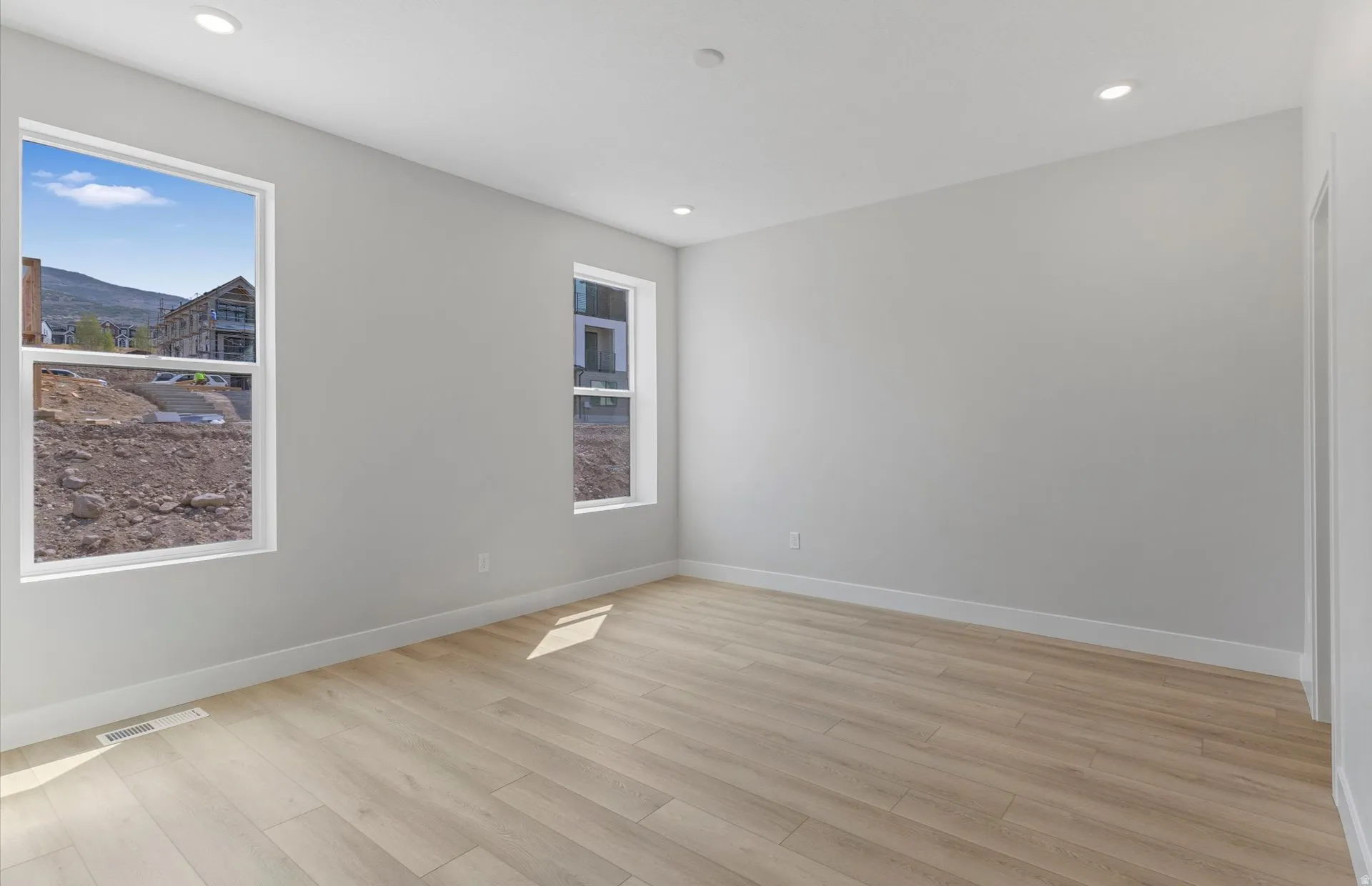 Recessed lighting, light wood-finish flooring, and multiple windows