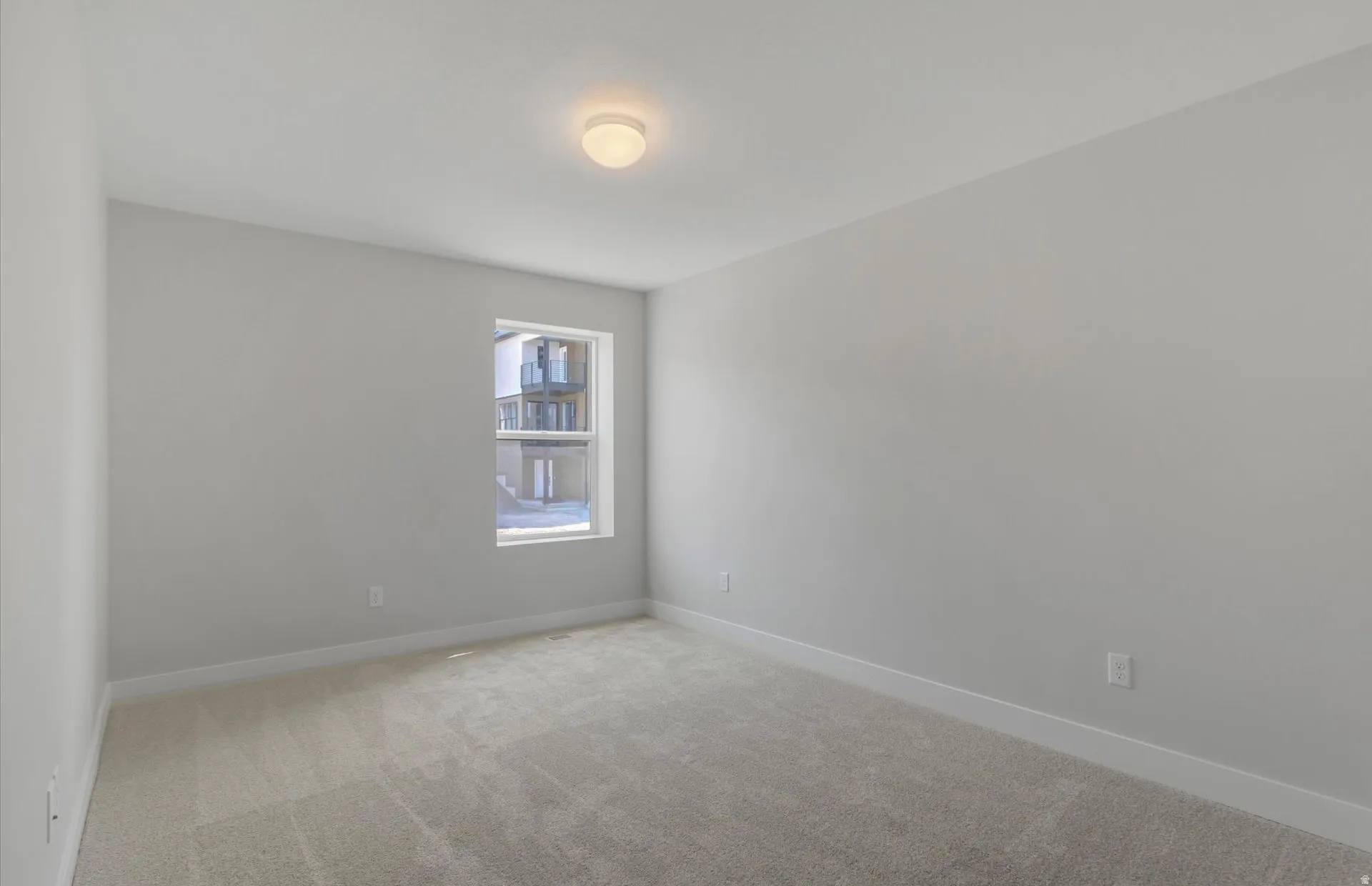 Recessed window, white trim, neutral wall paint, flush mount ceiling light, and carpeted flooring