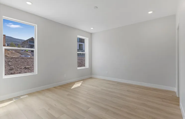 Recessed lighting, light wood-finish flooring, and multiple windows