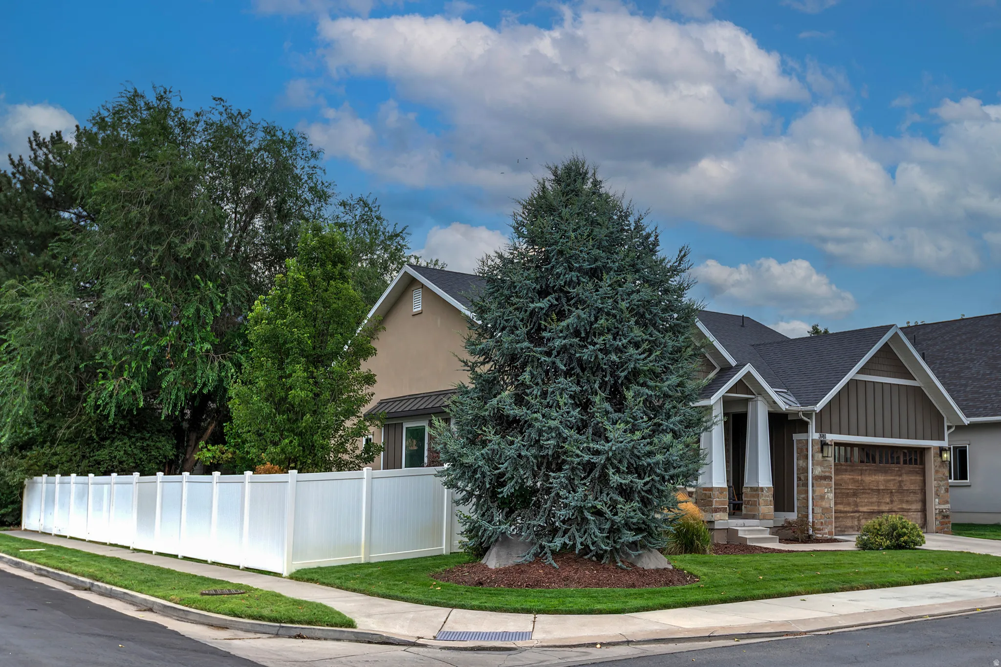 Charming two-story residence featuring a stone and siding exterior with peaked rooflines and an attached garage