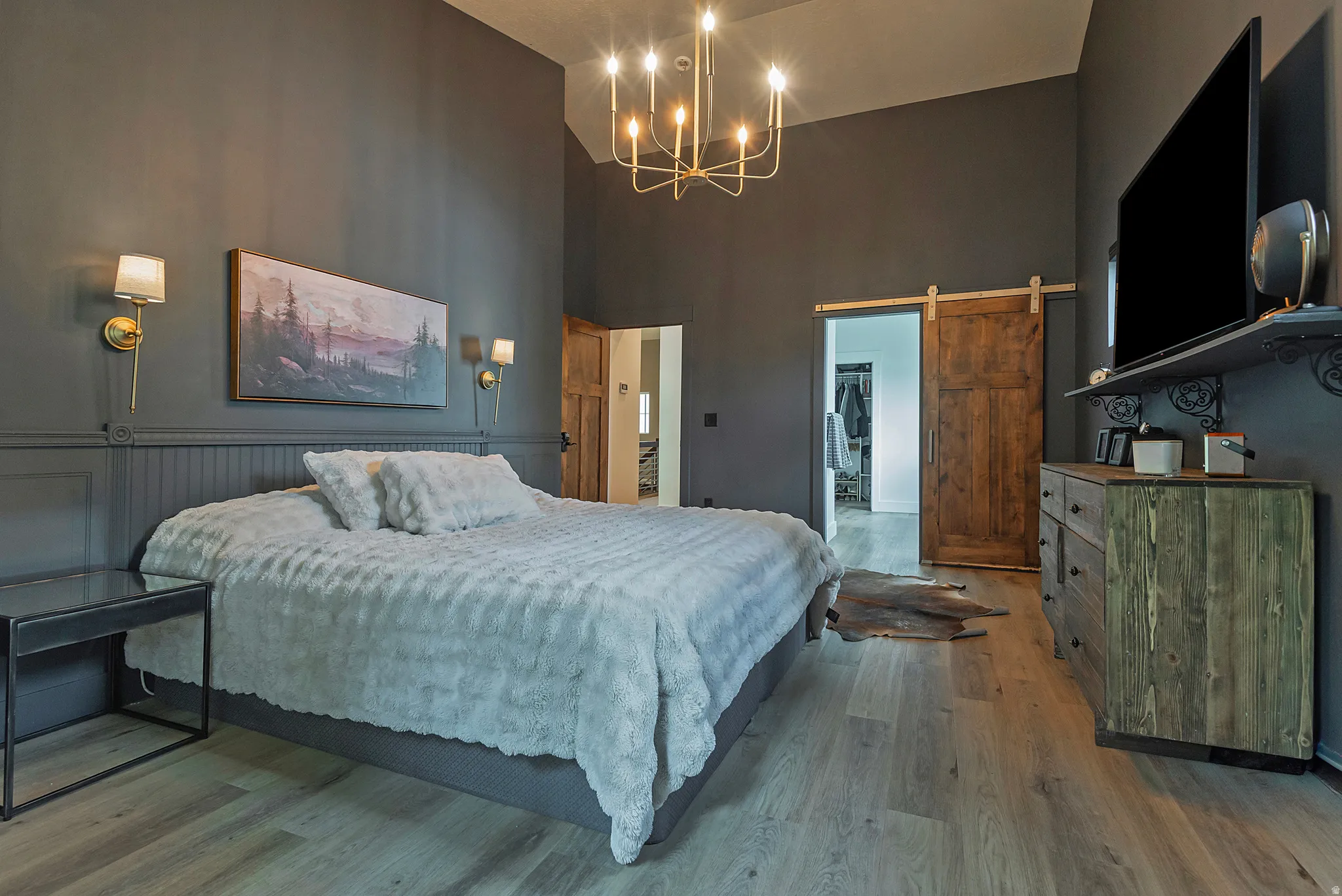 Master bedroom featuring warm taupe walls, wood-finish flooring, and coffered ceiling detail