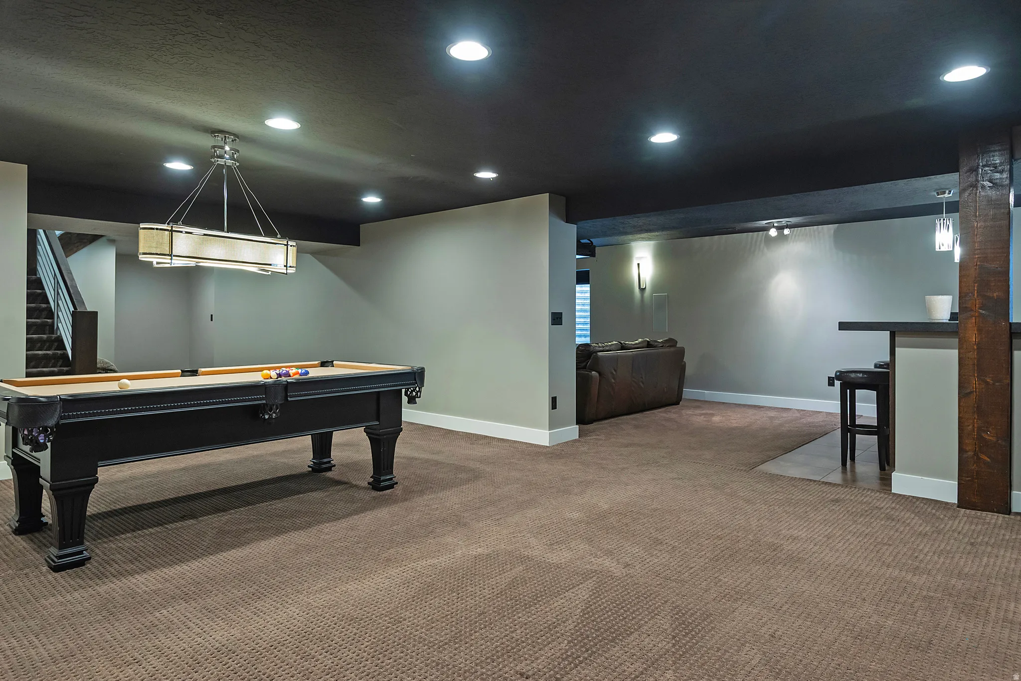 Recessed lighting, wood-finish beam, built-in wet bar with pendant lighting, and carpeted flooring