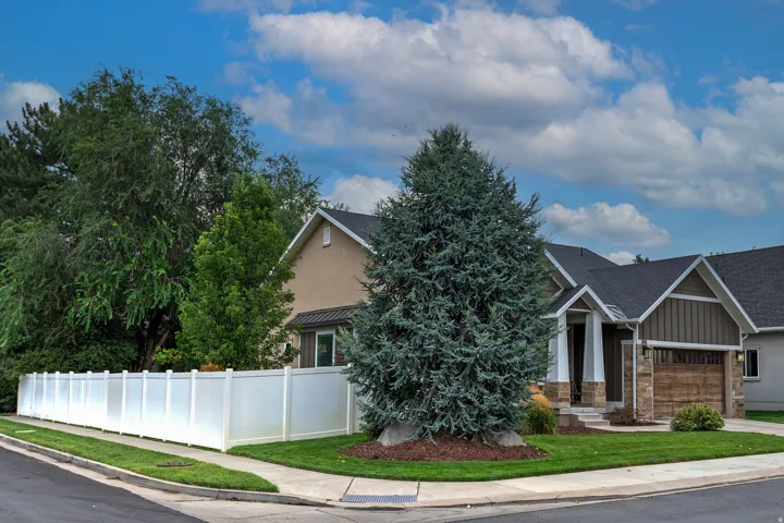 Charming two-story residence featuring a stone and siding exterior with peaked rooflines and an attached garage