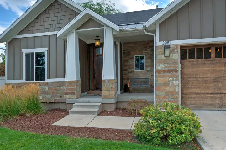 Stone and siding exterior with a wood-finish garage door