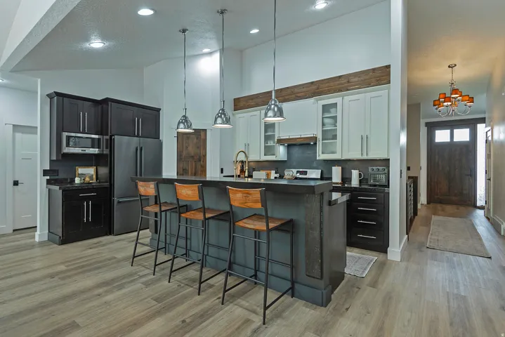 Chef's kitchen featuring dual stainless steel appliances, gray quartz countertops, and a large center island with seating
