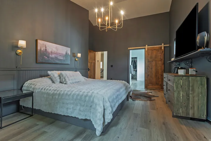 Master bedroom featuring warm taupe walls, wood-finish flooring, and coffered ceiling detail