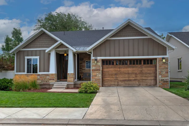 Contemporary ranch-style home featuring a charming brick and stone façade with mixed siding details