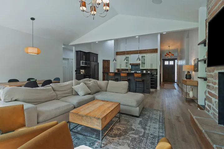Open-concept living space anchored by a generous sectional arrangement and wood-finish flooring throughout