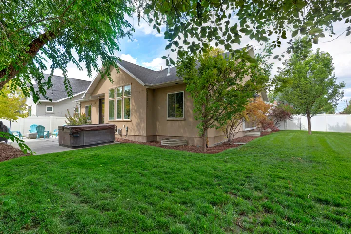 Expansive lawn area with mature trees and a privacy fence