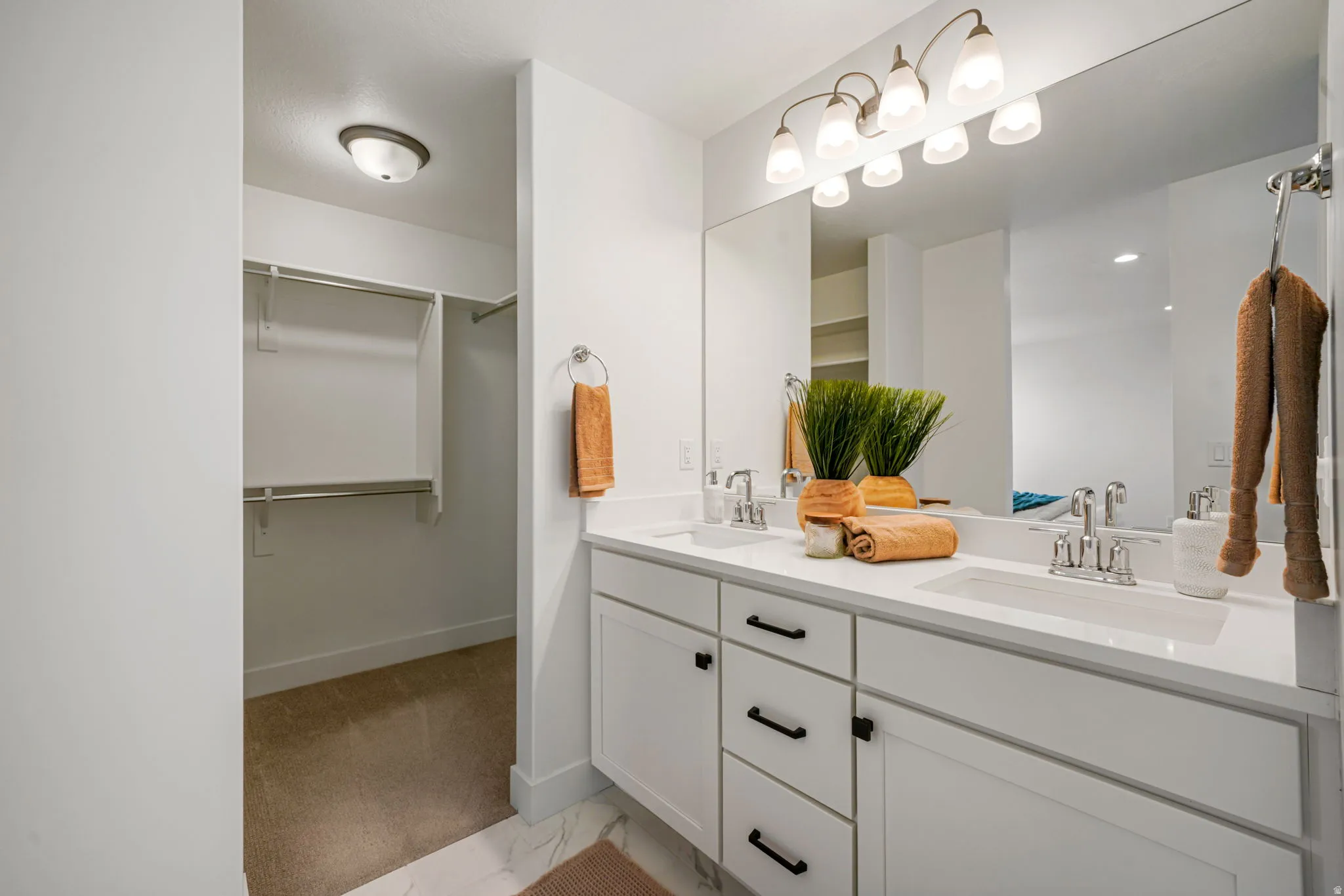 Spa-inspired primary bathroom featuring a dual-sink vanity with soft-close cabinetry, white quartz countertop, and chrome fixtures