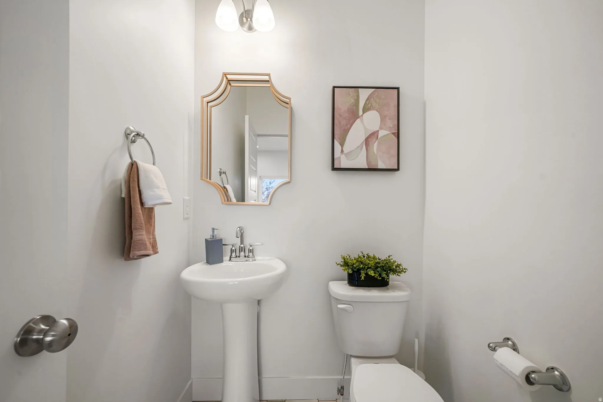 Powder room featuring a pedestal sink, decorative framed mirror with gilt-finish frame, white subway tile wainscoting, recessed ceiling lighting, and chrome fixtures