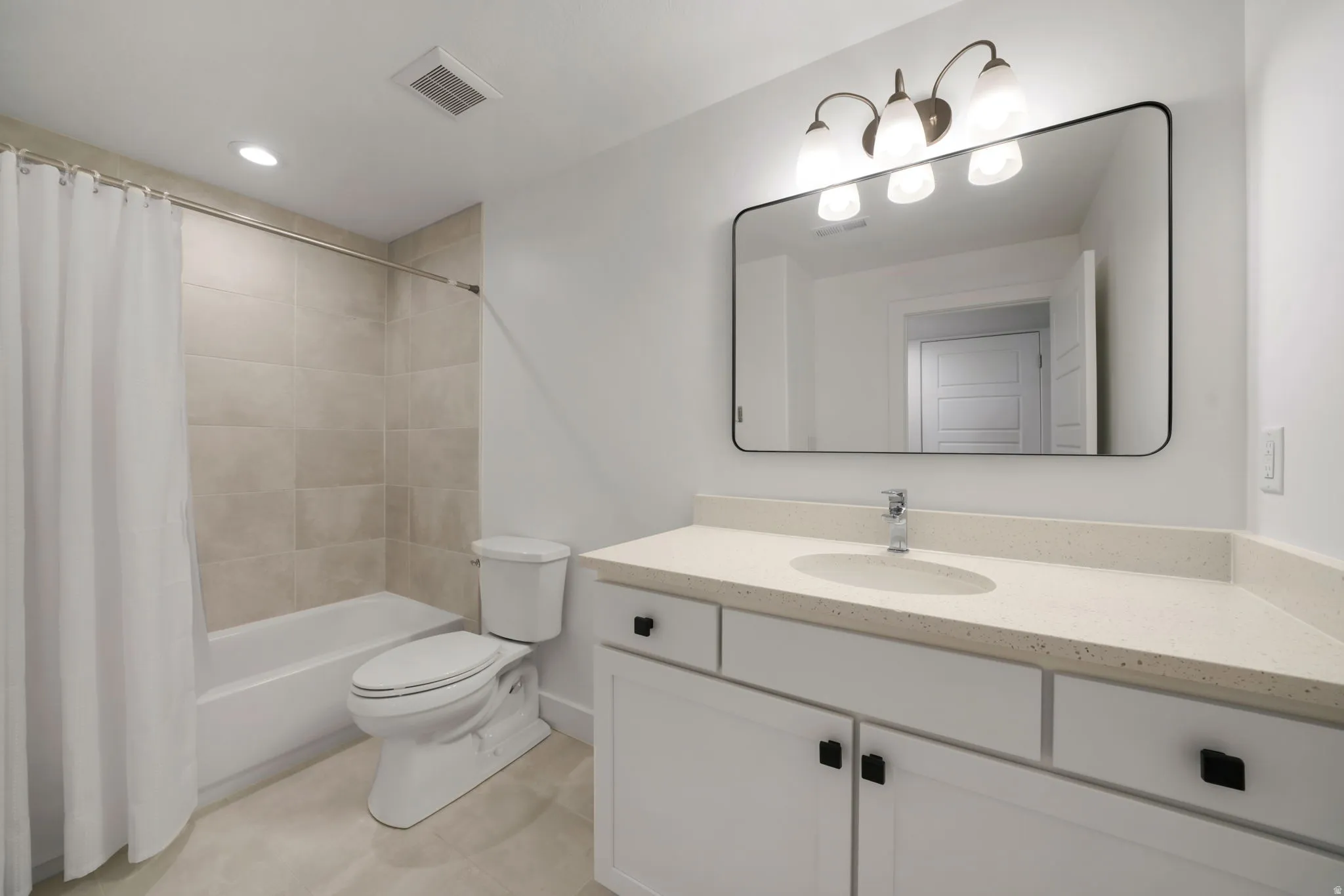 Modern bathroom featuring a floating vanity with dual drawers and cabinet storage, quartz countertop, rectangular undermount sink, and matte black hardware